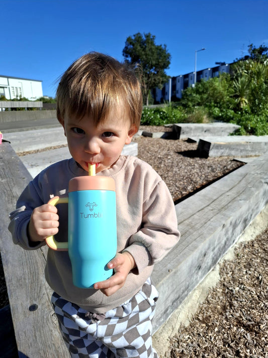 toddler holding blue stainless steel tumblii tumbler
