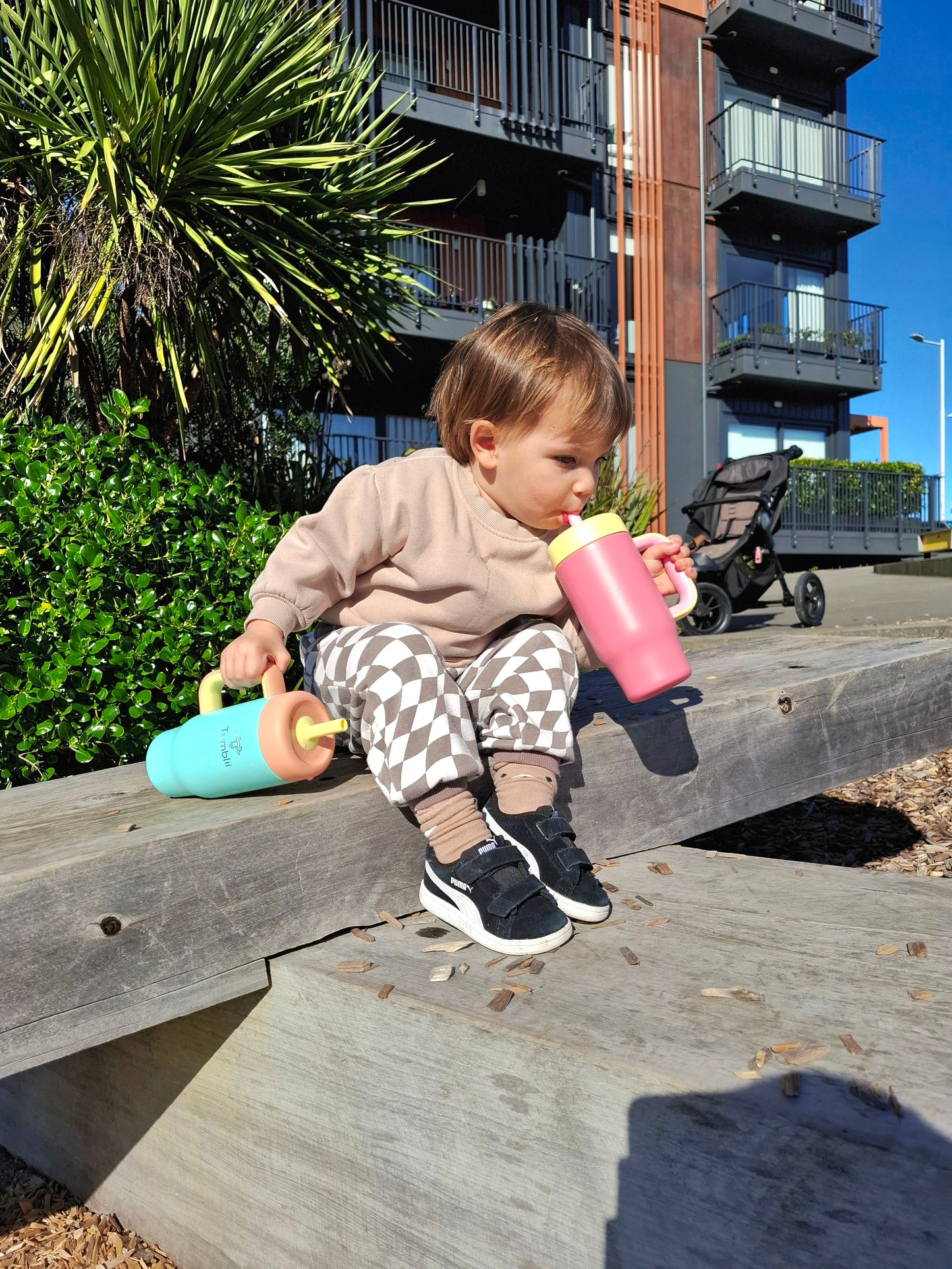 Child drinking from pink stainless steel tumbler